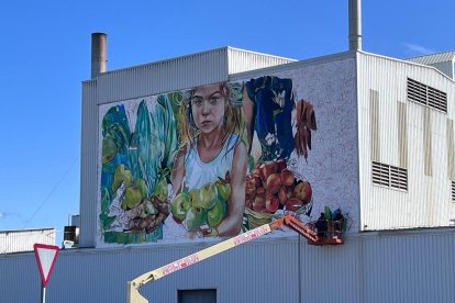 Lily Brick pintando el mural sobre la fruticultura del Pla d’Urgell en la sede de Nufri, en Mollerussa. 