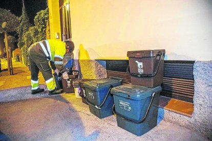 Un operari recollint les escombraries dels cubells que es deixen a la nit en un dels carrers d'Arbeca.