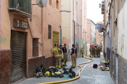 Efectius dels Bombers durant les tasques d'extinció en un bloc del carrer del Parc.