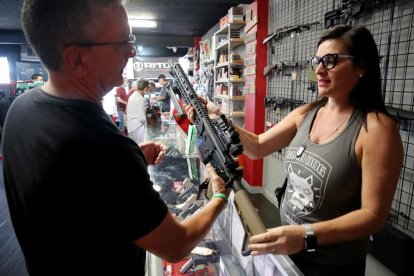 Un hombre observa un fusil en una tienda de armas en Florida.