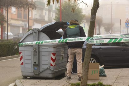 Guardias civiles buscan pruebas en un contenedor.