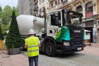 Un trabajador de la construcción ayuda a maniobrar a un compañero que conduce un camión.