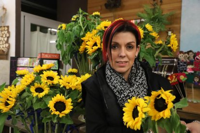 Natalia Rodríguez, de Flaires Dissenys Florals, sostenint dos gira-sols solidaris.