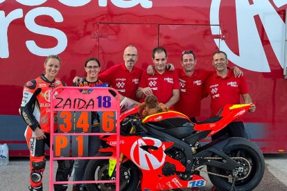 La pilot lleidatana, al costat de la moto i l’equip, mostra la seua pissarra amb la primera posició.