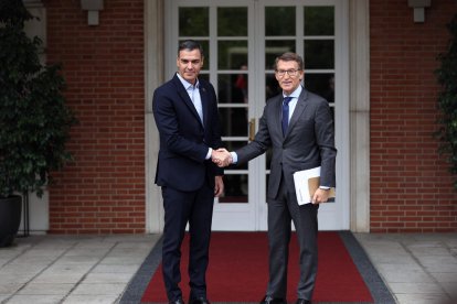 Pedro Sánchez y Alberto Núñez Feijóo se saludan a su llegada a una reunión en La Moncloa.