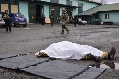 El cuerpo de una persona fallecida por los combates yace en una calle en el  Donbás.