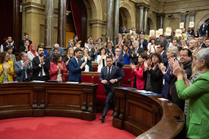 L’hemicicle va aplaudir després de l’aprovació de la norma i la CUP va ensenyar cartells en contra.