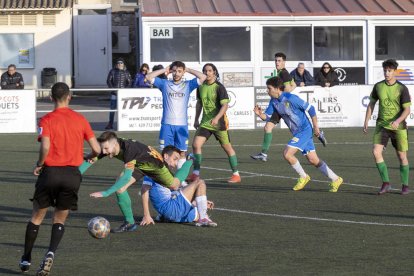 Un jugador de La Seu comete una falta sobre otro del Cervera ante la mirada del árbitro.