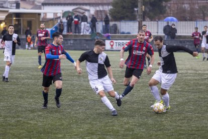 Dos jugadores del Horta combinan ante la presión de dos futbolistas del Tàrrega.