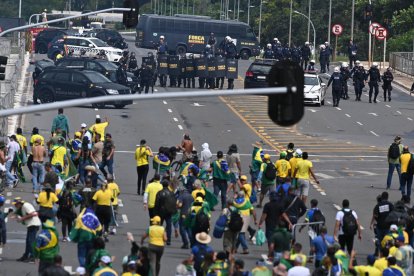 Fuerzas de seguridad brasileñas vigilan la llegada de simpatizantes de Bolsonaro ayer en Brasilia. 