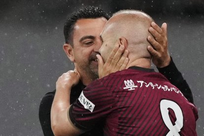 Xavi i Iniesta s’abracen durant el partit d’ahir.