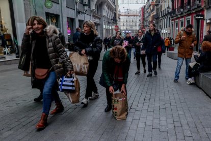 Diverses persones caminen amb bosses de les rebaixes al carrer Preciados de Madrid.