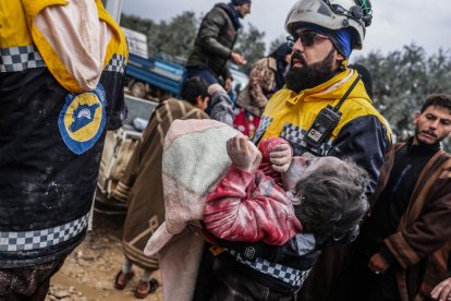 Membres dels Cascos Blancs sirians porten el cos d’una nena d’un edifici destruït a Harem, a prop de la frontera amb Turquia.