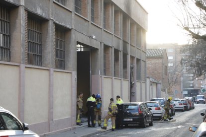 Agentes de los Mossos d'Esquadra y bomberos ayer por la mañana tras el incendio en la nave.