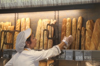 Imagen de archivo de una trabajadora de una panadería de Lleida cogiendo una barra. 