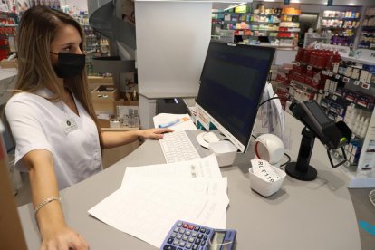 Una farmacèutica de Lleida ciutat intenta, sense èxit, dispensar un medicament.