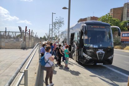 Foto de archivo de personas con mascarilla subiendo a un bus. 