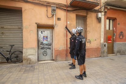 Agents de la Unitat Ciclista de la Urbana fent una ronda de vigilància en un immoble okupat.