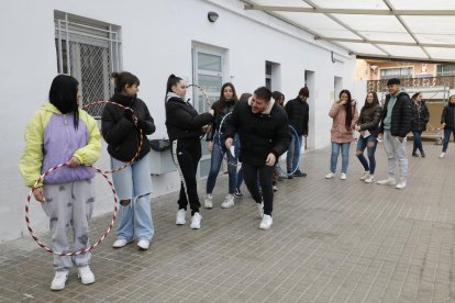 A l’esquerra, alumnes que simulen que són cotxes aparcats en colpegen un altre que simula que és un patinet per anar pel costat dret del carril. A la dreta, la sessió teòrica.