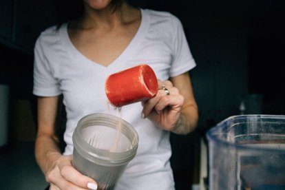 Imagen de archivo de una persona preparando un batido con proteina en polvo.