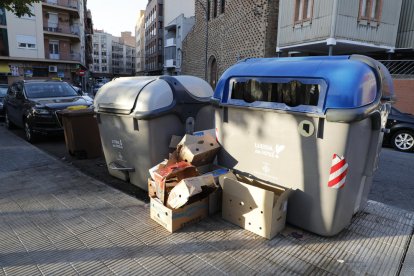 Caixes al costat d’un contenidor de paper i cartró a la plaça Santa Maria Magdalena (Clot).