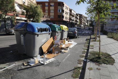 Caixes al costat d’un contenidor de paper i cartró a la plaça Santa Maria Magdalena (Clot).