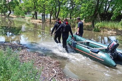 Rescatistes ucraïnesos arrosseguen un pot per evacuar civils atrapats per la inundació.