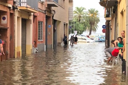 Veïns buiden aigua de les cases al carrer Sant Joan de Mataró després de l’aiguat de divendres.