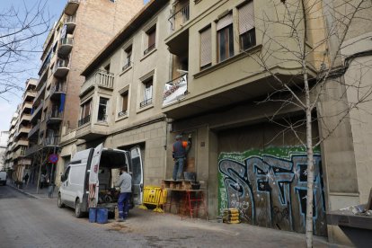 Dos operarios tapiando la puerta de acceso al número 11 de la calle General Brito, ayer al mediodía. 