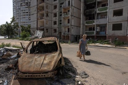 Una mujer pasa este lunes junto a un coche quemado en Chernígov, en el norte de Ucrania.