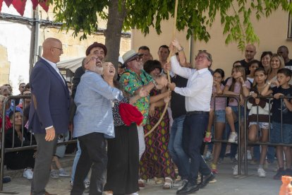 El conseller Giró, a la dreta amb camisa, participant en el concurs per pujar sacs amb corriola.