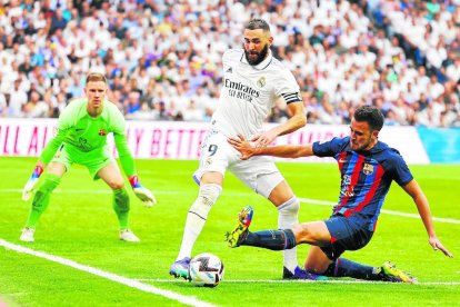 Eric Garcia, que va fallar en el segon gol blanc i va cometre el penal del 3-1, lluita per una pilota davant de Benzema.