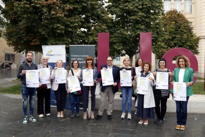 Representants d'Slowshop Lleida, PIMEC i la Paeria, en la presentació de les accions que es faran aquest octubre per reivindicar la reforma horària, davant l'estació de tren de Lleida