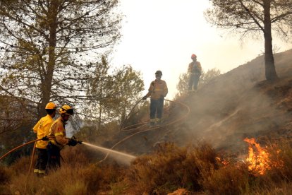 Los Bomberos apagando los fuegos de El Pont de Vilomara en julio.