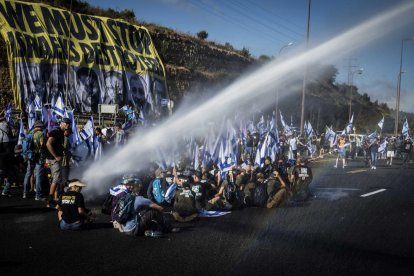 La Policía trata de despejar a los manifestantes que ocupaban las carreteras con cañones de agua.