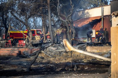 Los bomberos trabajan en un camping afectado por las llamas en Sant Andreu de Sureda.