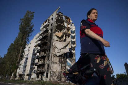 Una mujer camina cerca a un edificio destruido en Borodyanka.