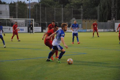 Un jugador del Mollerussa aguanta la posesión ante la presión de un rival del Alpicat.