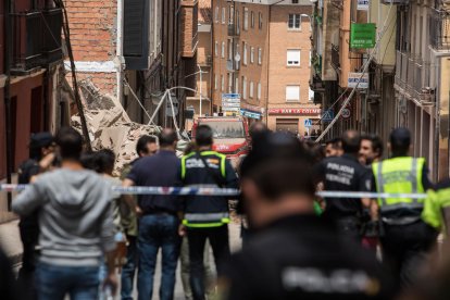 Agentes de la policia frente al edificio derrumbado.