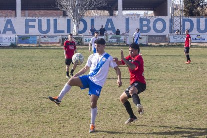 Un jugador de la Fuliola trata de controlar el balón ante la presión rival.