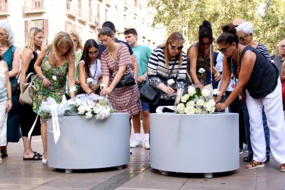 Víctimes i familiars dipositen flors sobre el Pla de l’Os, on el 2017 es va aturar la furgoneta després de l’atropellament massiu.