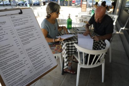 Dos clients miren la carta de preus del restaurant Cantamanyanes de Cappont, ahir al migdia.