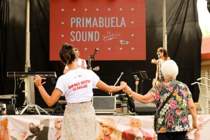 Una de las usuarias baila junto a una trabajadora del centro durante el concierto.