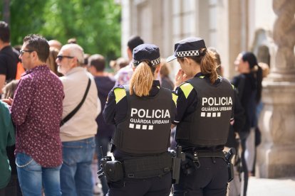 Dos agentes de la Guardia Urbana durante una patrulla por el Eix Comercial durante la Festa Major. 