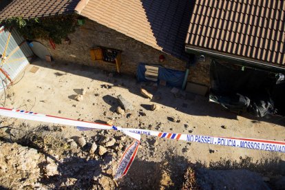 Valla y conos colocados para señalizar la zona (i). Antonio Travesi Pérez muestra los restos del muro que cayeron en su casa (d). 