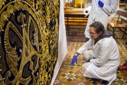 Las restauradoras trabajaron ayer durante todo el día para dejar el manto instalado en la nueva vitrina que lo albergará en la iglesia de La Sang.