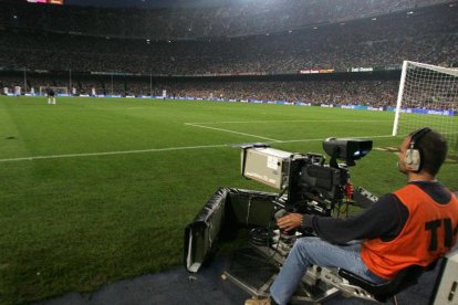 Operari de càmeres treballant durant la retransmissió d’un partit de futbol.