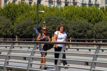 Una dona carregant ahir un ventilador a Lleida ciutat.