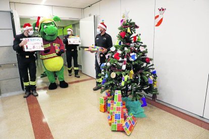 La ACR Bombers de Lleida, junto con el Marraquet Bomber, descargó los regalos en el servicio de Pediatría con un camión-escalera de más de 40 años. 