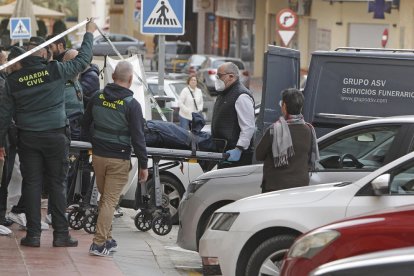 Los servicios funerarios retiran el cadáver de la víctima.